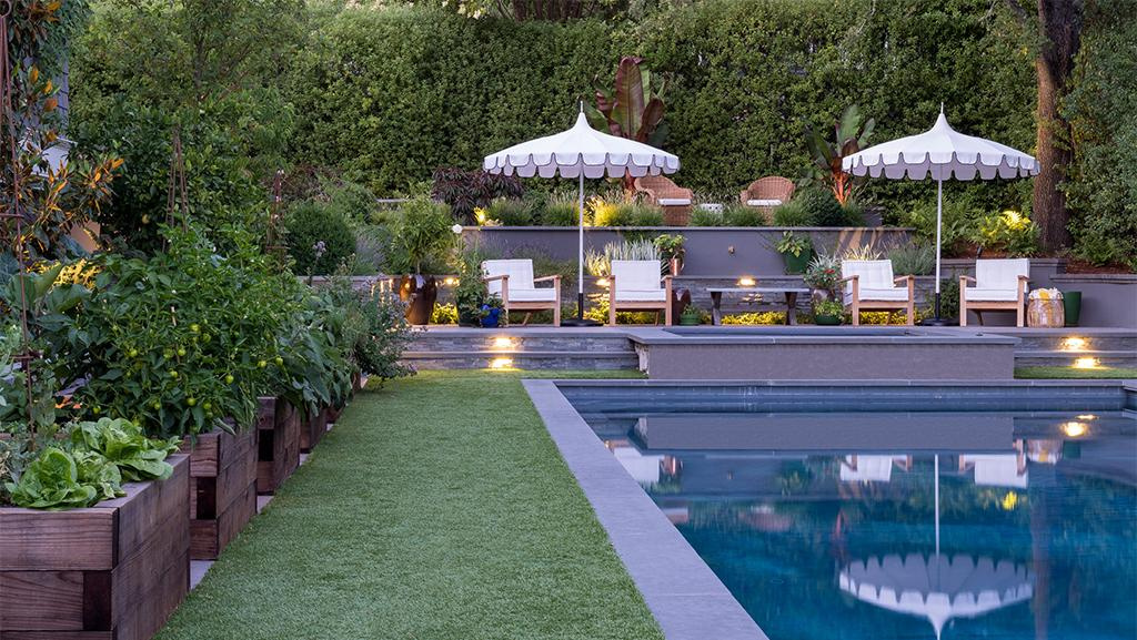 edible landscape design with kitchen garden in raised beds next to a pool