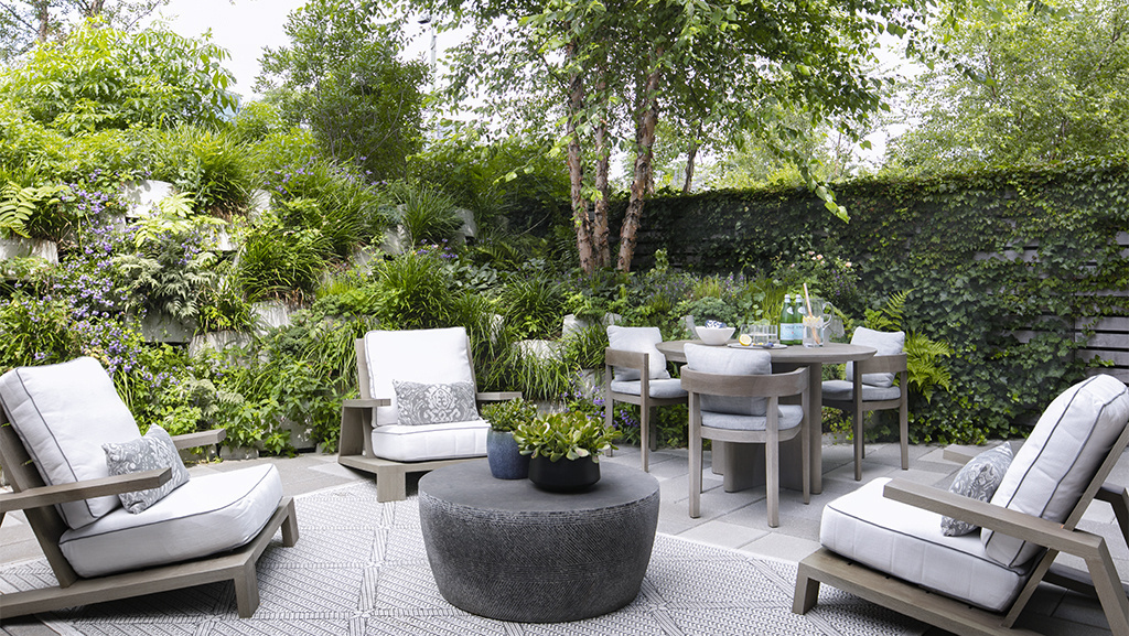 three outdoor lounge chairs around a coffee table in outdoor room