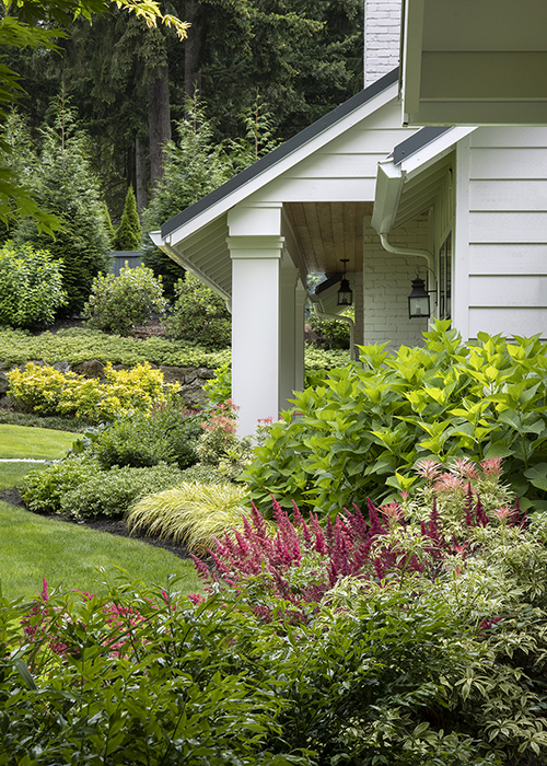 layered garden bed in front of house